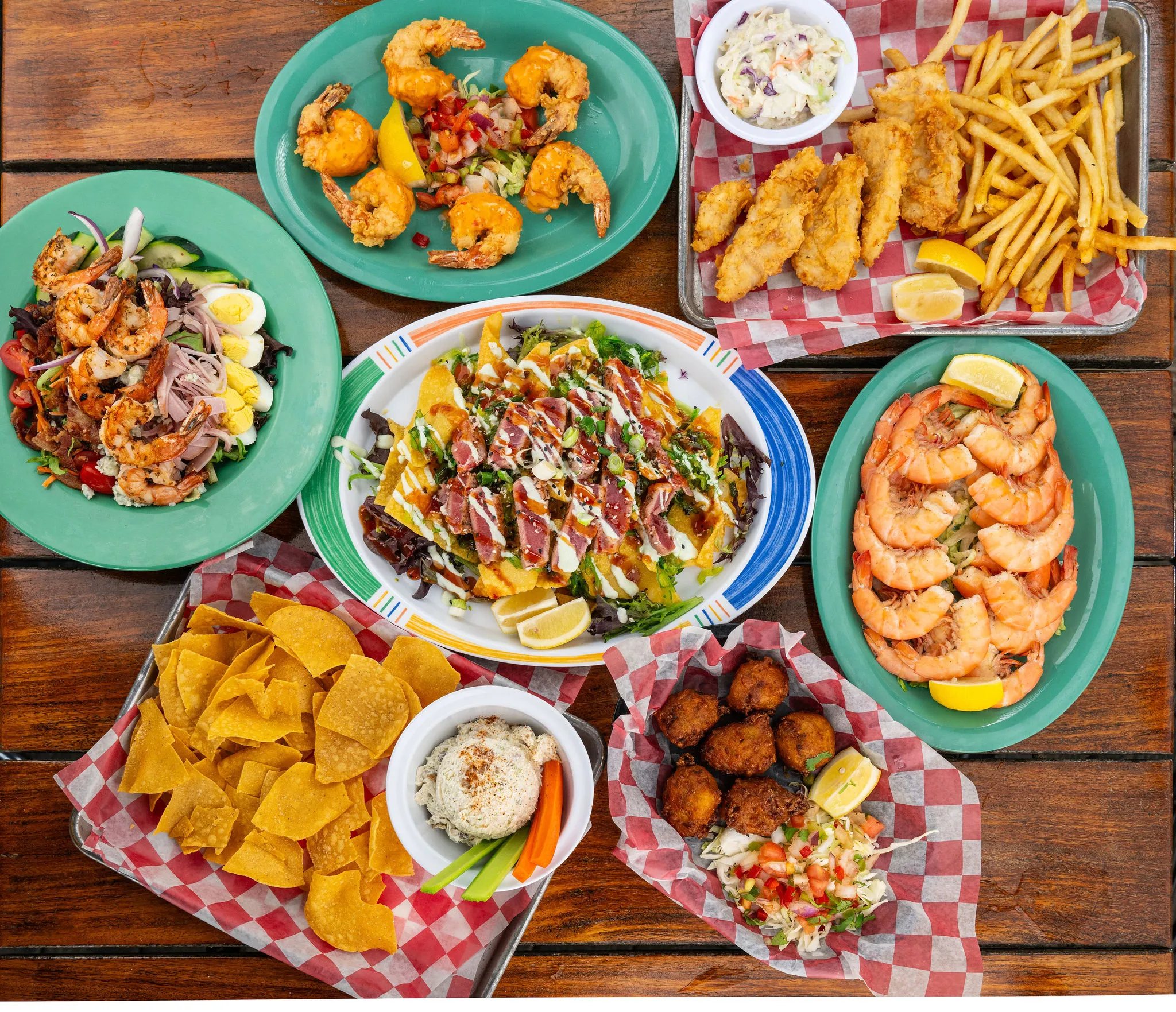 A spread of dishes including shrimp, fried fish, salad, and more