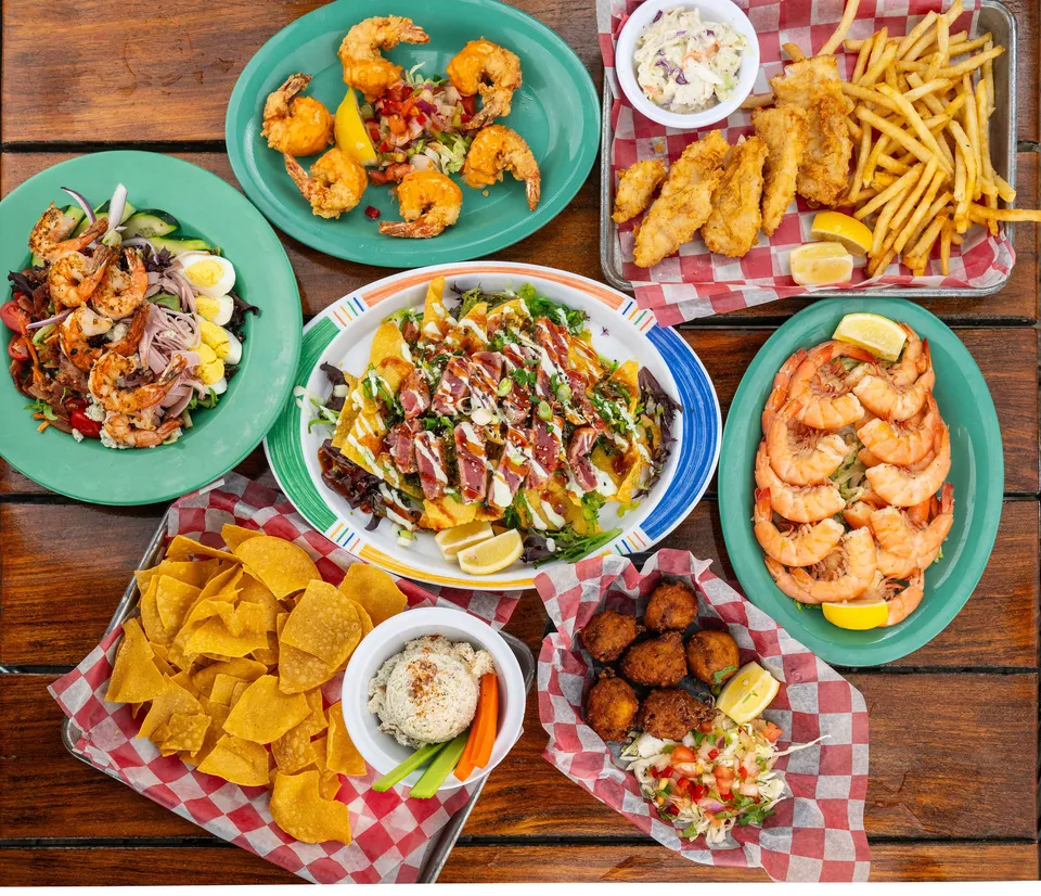 A spread of dishes including shrimp, fried fish, salad, and more