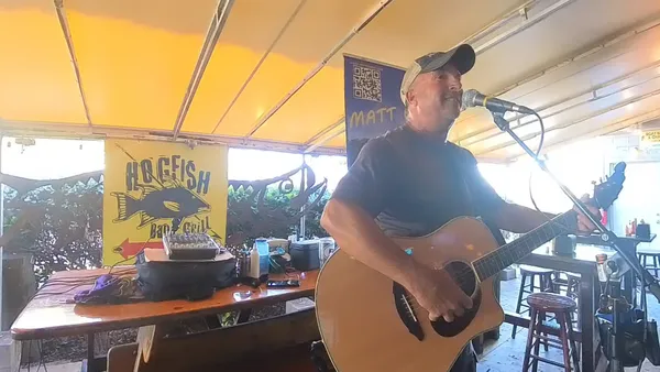 Matt Gardi performing on stage with an island feel