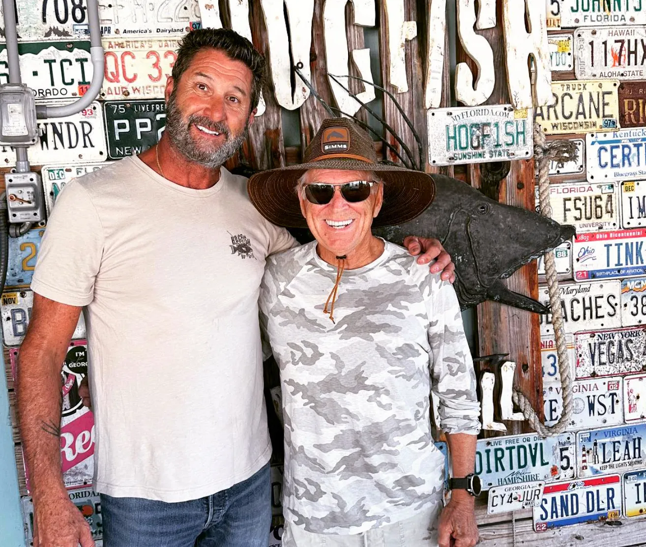 Hogfish Bar & Grill owner Bobby Mongelli with Jimmy Buffett in front of the license-plate wall